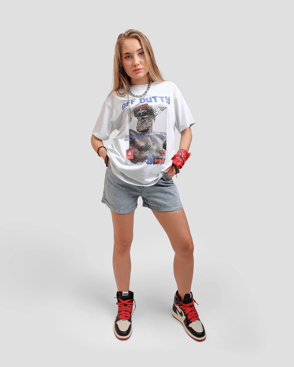 Fifth photo is A female Russian model in a dynamic pose, wearing Off Dutty's 'Embracing Your Presence' white relaxed t-shirt paired with a jeans short and Air Jordan 1 Retro High OG NRG 'Not For Resale' sneaker. She complements her look with a chain necklace and some bracelets, and a red pendant on her left hand.