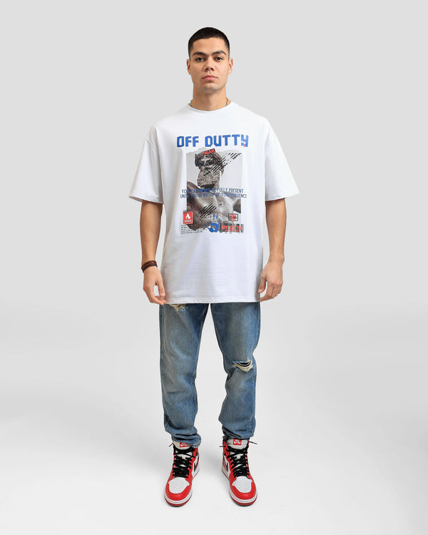 Front photo of a white Turkish look a like male model in a light grey backdrop wearing 'Embracing Your Presence' white relaxed T-shirt from Off Dutty's 'Rare and Radiant' collection, paired with striped jeans and an Air Jordan 1 Retro High OG 'Chicago' 2015 sneaker. He accessorizes with necklaces, three bracelets on his right hand.