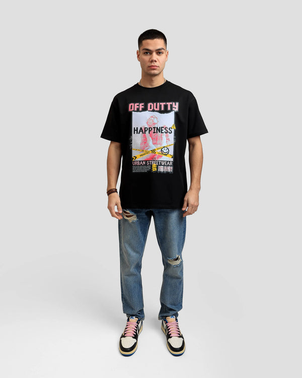 Front photo of a white Turkish look a like male model in a light grey backdrop wearing 'What Is Happiness' black relaxed t-shirt from Off Dutty's 'Rare and Radiant' collection, paired with striped jeans and Air Jordan 1 Low Travis Scott. He accessorizes with necklaces, three bracelets on his right hand.