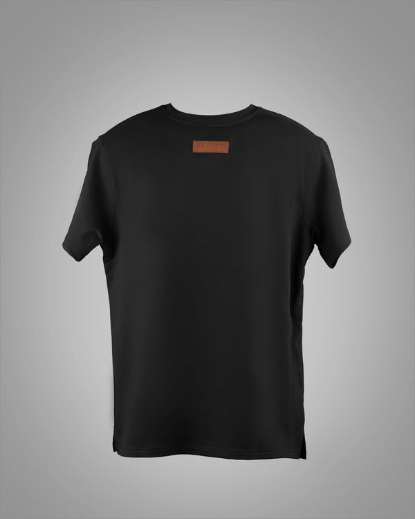 Back view of Off Dutty's 'What Is Happiness' black relaxed t-shirt from the 'Rare and Radiant' collection, showcased against a light grey background, emphasizing the sleek and clean design of the tee's rear.