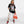 Fifth photo is A female Russian model in a dynamic pose, wearing Off Dutty's 'Embracing Your Presence' black relaxed t-shirt paired with white cargo pants and Air Jordan 1 Retro High OG NRG 'Not For Resale' sneakers. She complements her look with orange sunglasses and a matching handbag, exuding attitude as she gazes towards the t-shirt.